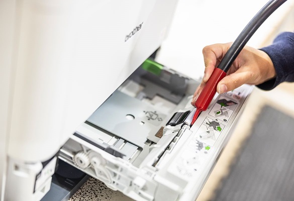 Mand roder ved en åben Brother-printer