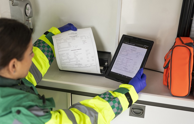 Person der printer fra en mobl printer på et bord